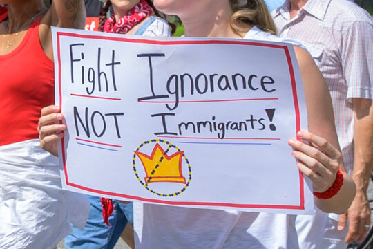 "Fight Ignorance, Not Immigrants" sign and unidentified No Kings marchers in New Orleans, LA, USA