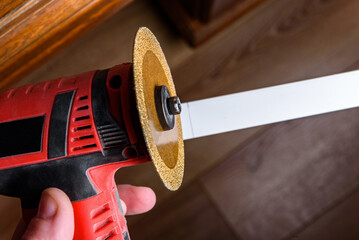 Measuring and cutting a plastic cable channel box using grinder.