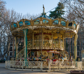 Close-up photo focusing on a carousel with detailed classic ornaments in bright colors © pedro