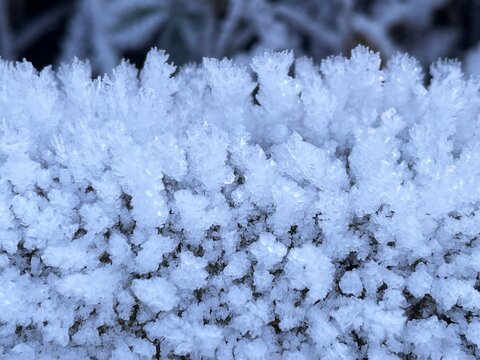 Intricate frost crystals forming delicate patterns on a cold surface. Close-up view of delicate ice formations and frost patterns created by freezing temperatures and moisture in the air