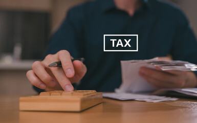 Businessman hand using calculator to budgeting and tax calculation monthly expenses. budget management and accounting on table. Business finance accounting banking concept.