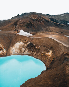 View of a striking contrast between the turquoise lake nestled against the rugged, earthy mountains, creating a surreal and breathtaking landscape, Askja, Highlands, Iceland.
