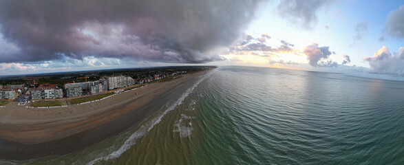 Nieuwpoort, West-Vlaanderen, Belgium, September 13th, 2025, A breathtakingly stunning view of a pristine beach coastline located beneath vibrant and colorful clouds during sunset
