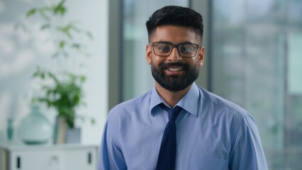 Fototapeta premium Portrait in office happy smiling Arabian ethnic Muslim business man Indian businessman looking at camera carefree positive male professional guy corporate manager employer entrepreneur agent smile
