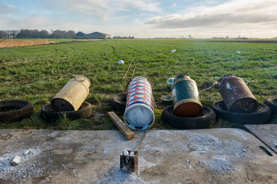 Old milk cans in a row. Carbide shooting or carbidschieten in dutch is a tradition in the Netherlands and usually takes place on New Year's Eve. The goal is to make a loud bang after the carbide