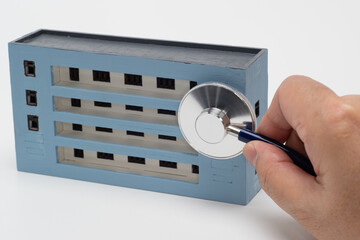 マンションの模型と聴診器で住宅診断のイメージ
