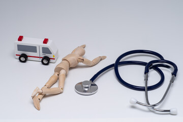 倒れた人形と救急車と聴診器