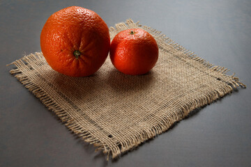 Orange and tangerine on a small linen napkin. Citrus background.