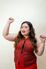 Plus-size woman celebrating success with raised fists, confident and joyful