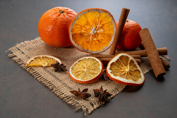 Dried orange slices, cinnamon and star anise on a brown wooden background. Spices for mulled wine