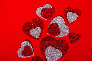 Red and Silver Glitter Hearts on Red Background with Copy Space. Romantic Valentines Day concept symbolizing love, affection, and celebration, with ample copy space for text or design.