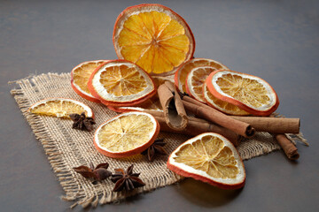Dried orange slices, cinnamon and star anise on a brown wooden background. Spices for mulled wine