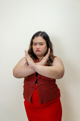 Woman crossing arms in refusal gesture, saying stop with angry expression, body positivity