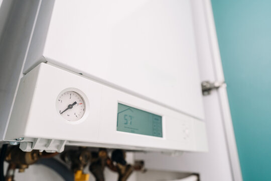 Modern heating system boiler with control panel in utility room