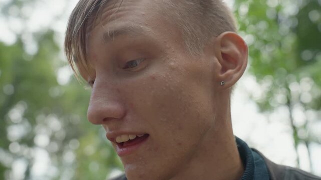 intimate outdoor forest portrait man sweaty skin subtle earring pensive gaze eyes shifting between camera and distance rehearsing monologue in natural light quiet tension cinematic shallow depth raw