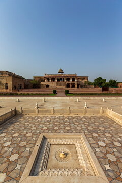 View of the historic Lahore Fort's sun-drenched courtyard, with intricate geometric patterns leading to the majestic building, Lahore Fort, Punjab, Pakistan.