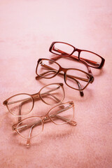 Assortment of eyeglasses, womens glasses on bright pink background