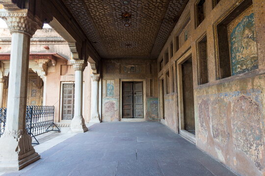 View of weathered walls with fading murals and intricate ceiling patterns create a timeless scene in Lahore Fort, Lahore, Punjab, Pakistan.