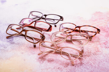 Assortment of eyeglasses, womens glasses on bright pink background