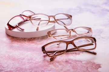 Assortment of eyeglasses, womens glasses on bright pink background