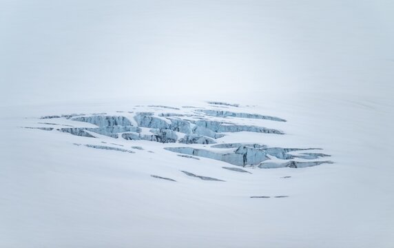 Smooth white snowy area on the glacier broken by crevasses with blue rugged glacial ice, detail, Exit Glacier, Kenai Peninsula, Alaska, USA