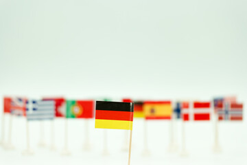 Collection of small flags representing different countries with a focus on the German flag in the foreground