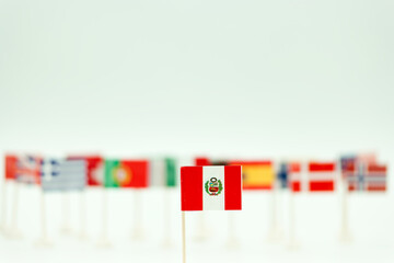 Collection of small flags arranged on a table showing different countries with focus on Peru
