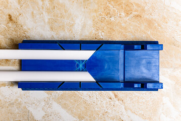 Cutting the corner of ceiling moldings from white polystyrene foam with a clerical knife using a...