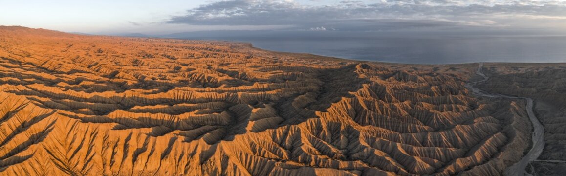 Landscape of eroded hills at Lake Issyk Kul, Badlands at sunrise, aerial view, Canyon of the Forgotten Rivers, Issyk Kul, Kyrgyzstan