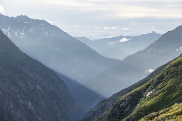 Atmospheric mountain landscape, sunbeams fall between peaks into a mountain valley, evening light, Floitengrund valley, Greizer Hütte, Berliner Höhenweg, Zillertal Alps, Tyrol, Austria