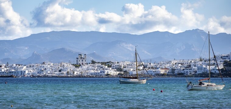 Local view of Naoussa town and blue sea, white Cycladic houses and church Agios Faneromeni, Paros, Cyclades, Greece