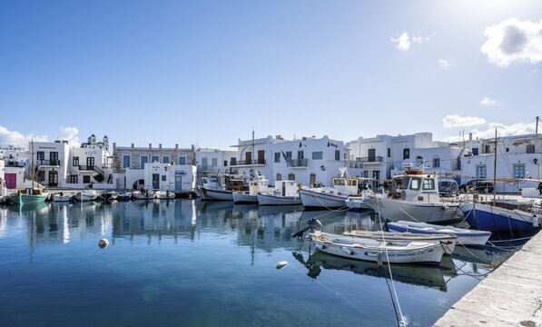 Fishing boats in Naoussa harbour with reflection, White Cycladic houses, Naoussa, Paros, Cyclades, Greece
