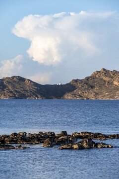 Rocky coast with lighthouse Akrotiri Korakas with blue sea, Paros, Cyclades, Greece