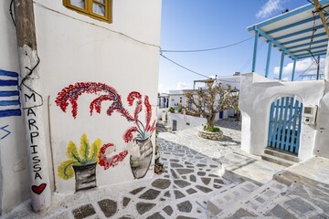 Painted house wall with inscription Marpissa and flowers, white Cycladic houses, picturesque alleys of the village Marpissa, Paros, Cyclades, Greece