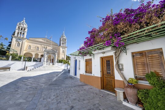 White Cycladic house with purple bougainvillea and Agia Triada church, Lefkes, Paros, Cyclades, Greece
