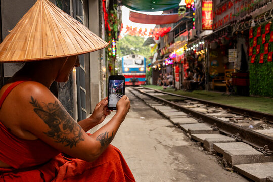 Tourist capturing train on Hanoi Train Street in Vietnam
