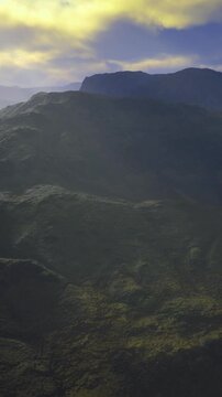 Shadowed mountains with contrasting shadowy valleys, Twilight mountains cast in deep shadow with dramatic contrasts under brooding blue clouds