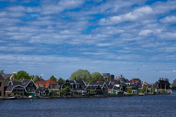 View of the village of Zaandijk on the Zaan River on a sunny day with white clouds.