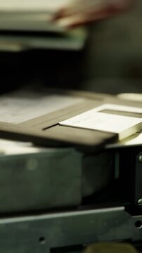 Stacked documents with aged floppy disk present, Arrange of files and old disk demonstrating storage and preservation responsibilities in office setting