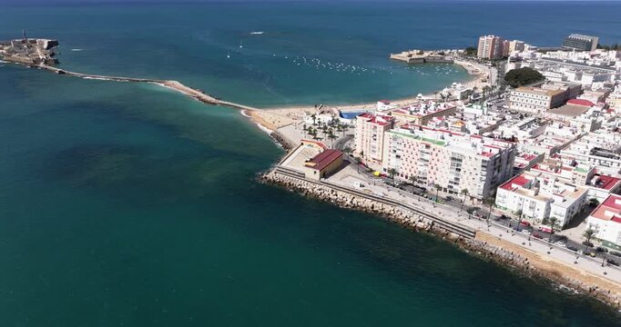 Aerial drone cityscape view of C&aacute;diz in Spain, Andalusia, Europe, on bright sunny day, facing Cadiz Cathedral and waterfront. Drone panning fast. Commercial grading