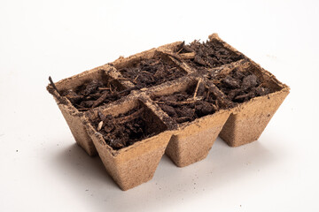 Peat Pots Filled With Dirt Ready to Plant Seeds for a Garden Isolated on a White Background