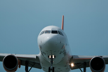 Front view of a commercial airplane flying in the sky, detailed nose and cockpit windows.