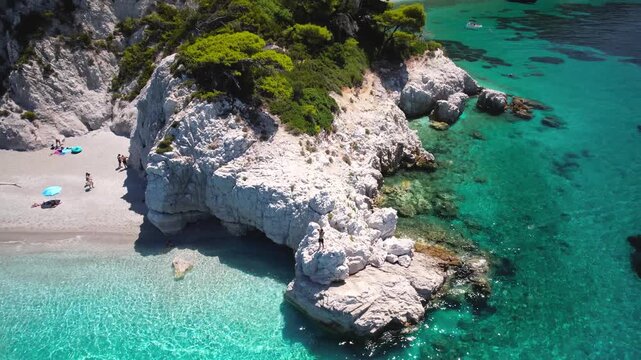 People Jumping from High White Limestone Cliffs into Turquoise Sea, Summer Adventure at Hovolos (Hovolo) Beach, Skopelos Island, Greece