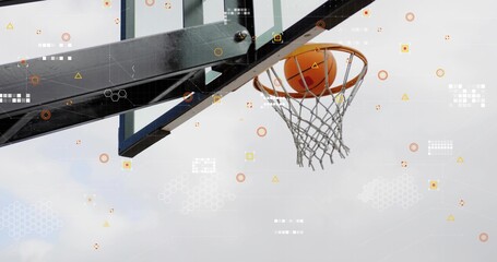 Sinking orange basketball through metal rim net support arm and icons at outdoor court, copy space
