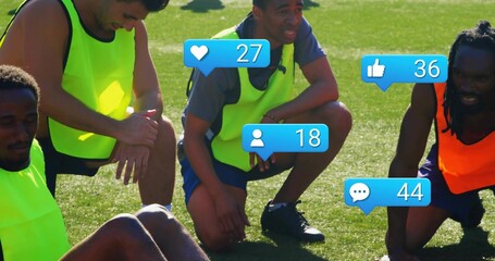 Gathering four soccer players wearing neon pinnies and cleats, resting on grass with blue badges