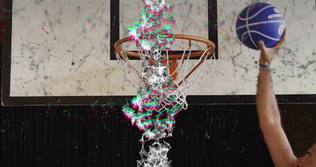 Shooting player reaching right arm to hoop at gym holding purple basketball with glitch in jersey