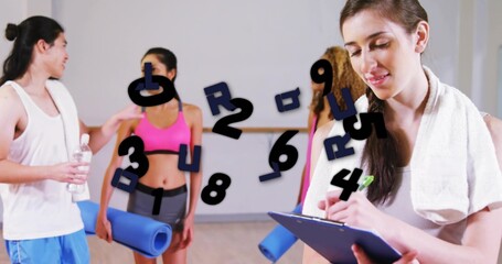 Holding clipboard, instructor writing notes at fitness studio, with blue mats and towel, copy space