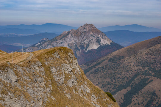 View of rugged mountain peak piercing the sky, with golden grasses clinging to the foreground cliffs, Mala Fatra's beauty unfolds, Chleb, Zilina Region, Slovakia.