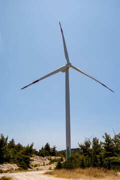Wind turbine in a rural landscape under clear blue sky