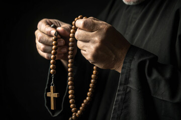 Hands Holding Rosary Beads in Low Light Symbolizing Lenten Devotion